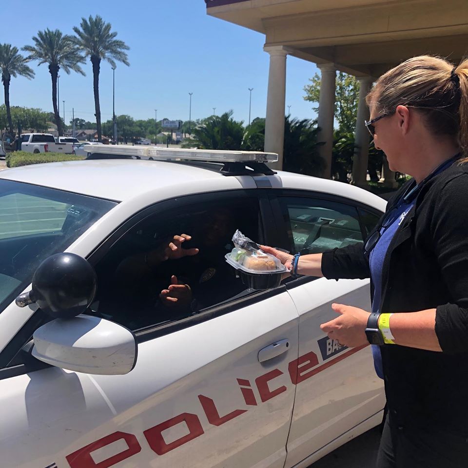 woman handing policeman in a car food