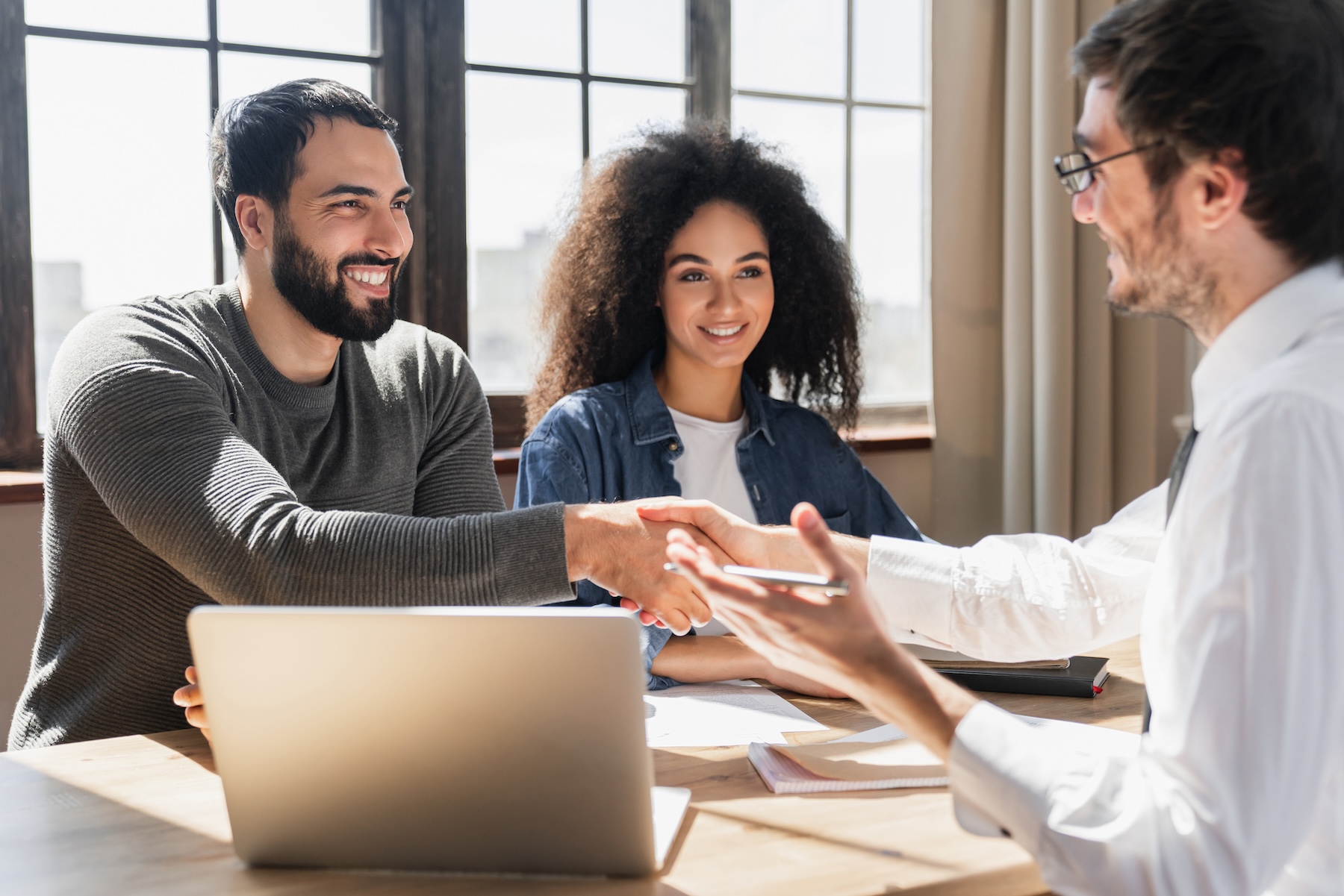Couple shaking hands with a mortgage loan officer