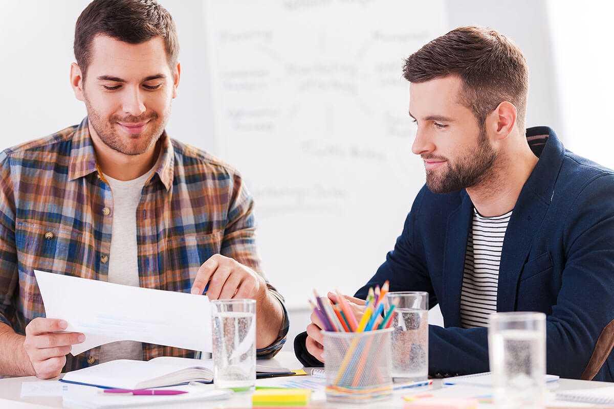 Two men review and discuss a document pertaining to a mortgage on a home in Baton Rouge