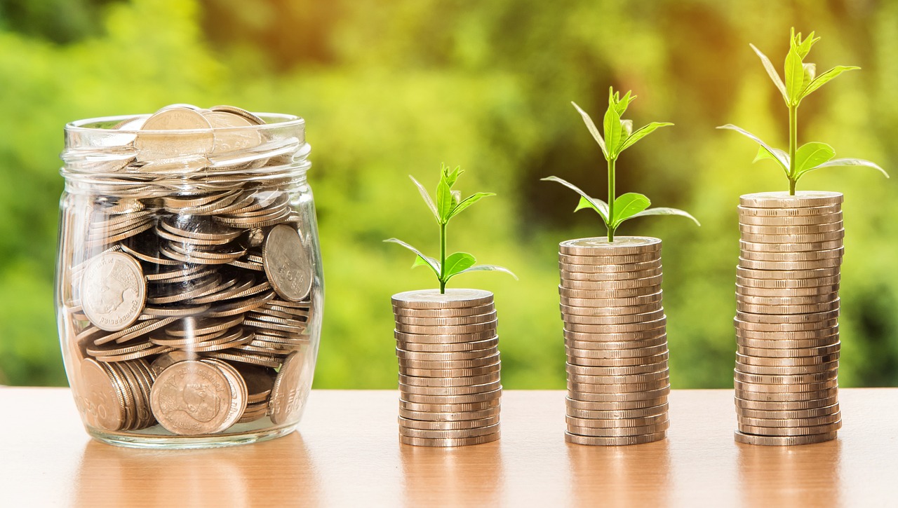 A jar of quarters next to three stacks of quarters at different heights, depicting refinancing for debt consolidation services from GMFS Mortgage
