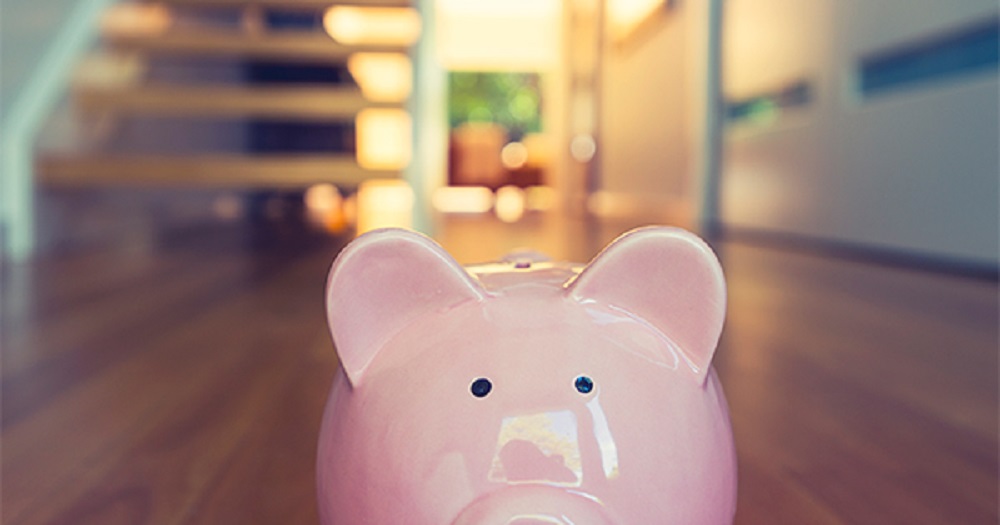 A piggy bank placed atop hardwood flooring in a home