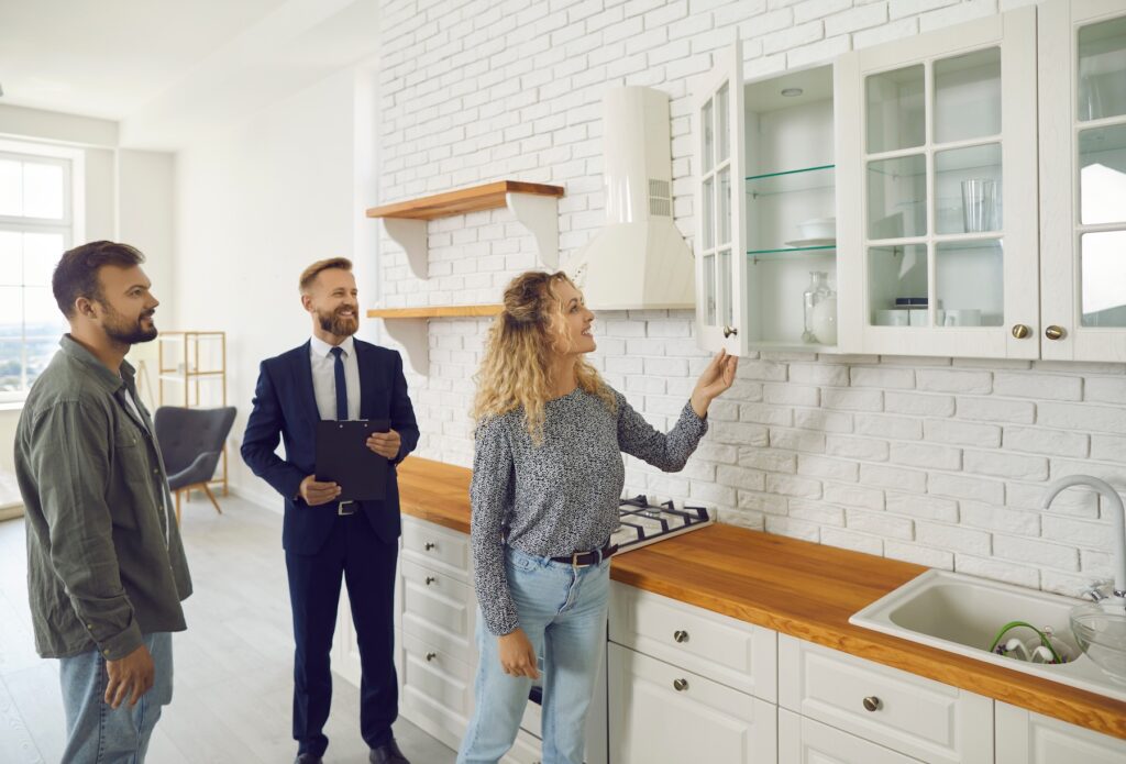 Young couple looking through home for sale with the help of an agent