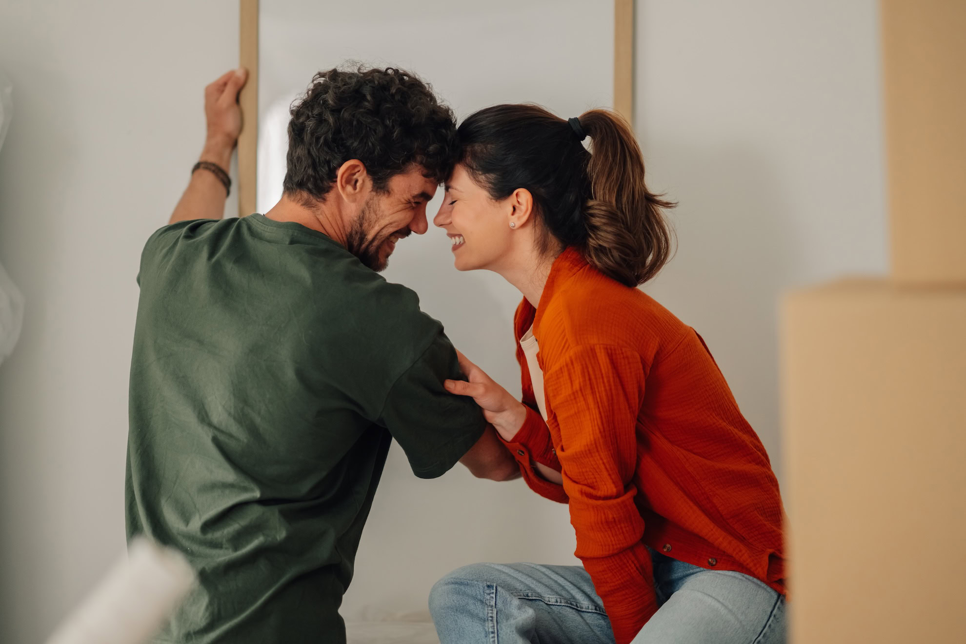 Happy couple hanging a picture frame in new home