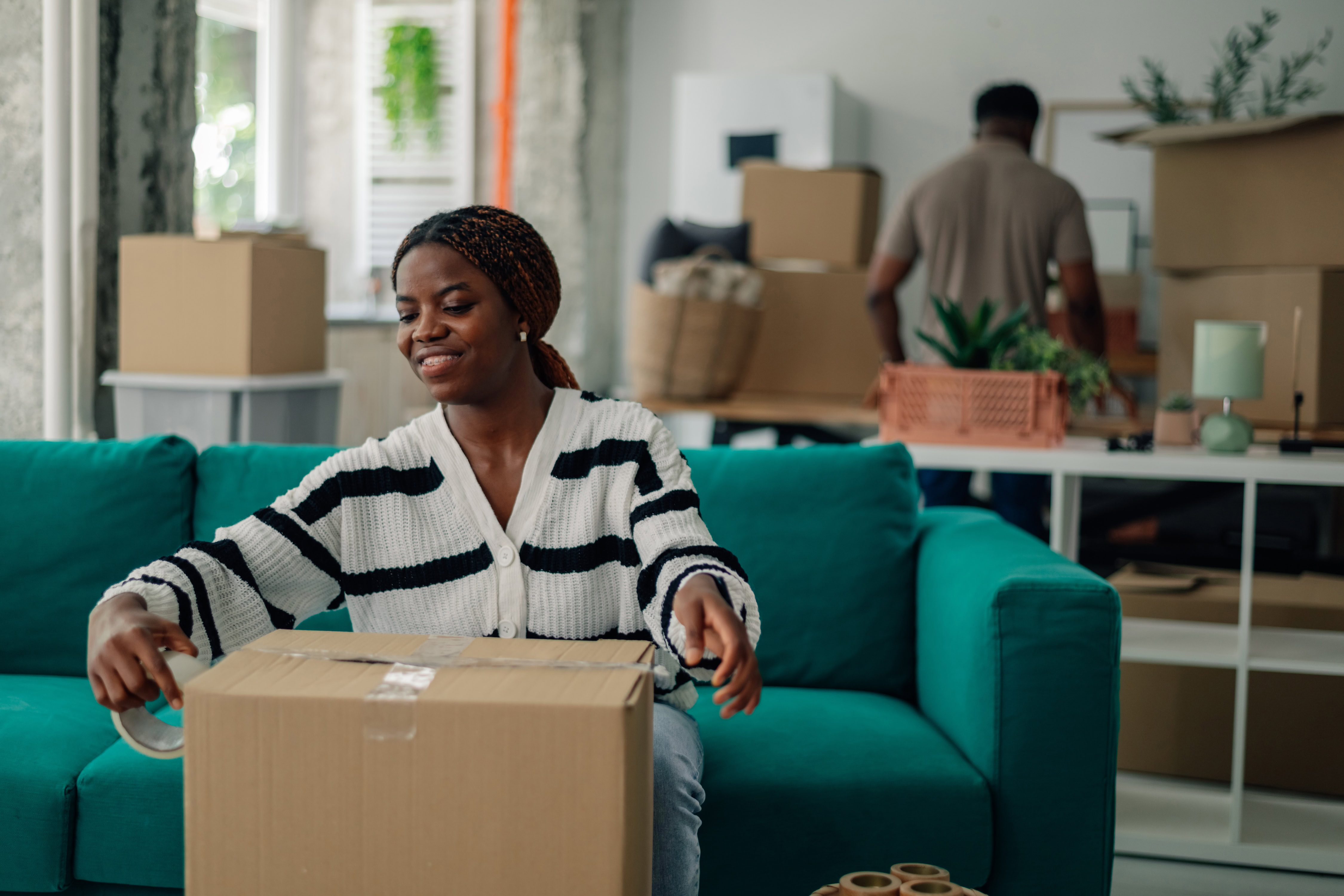 Happy homeowners packing belongings into cardboard boxes
