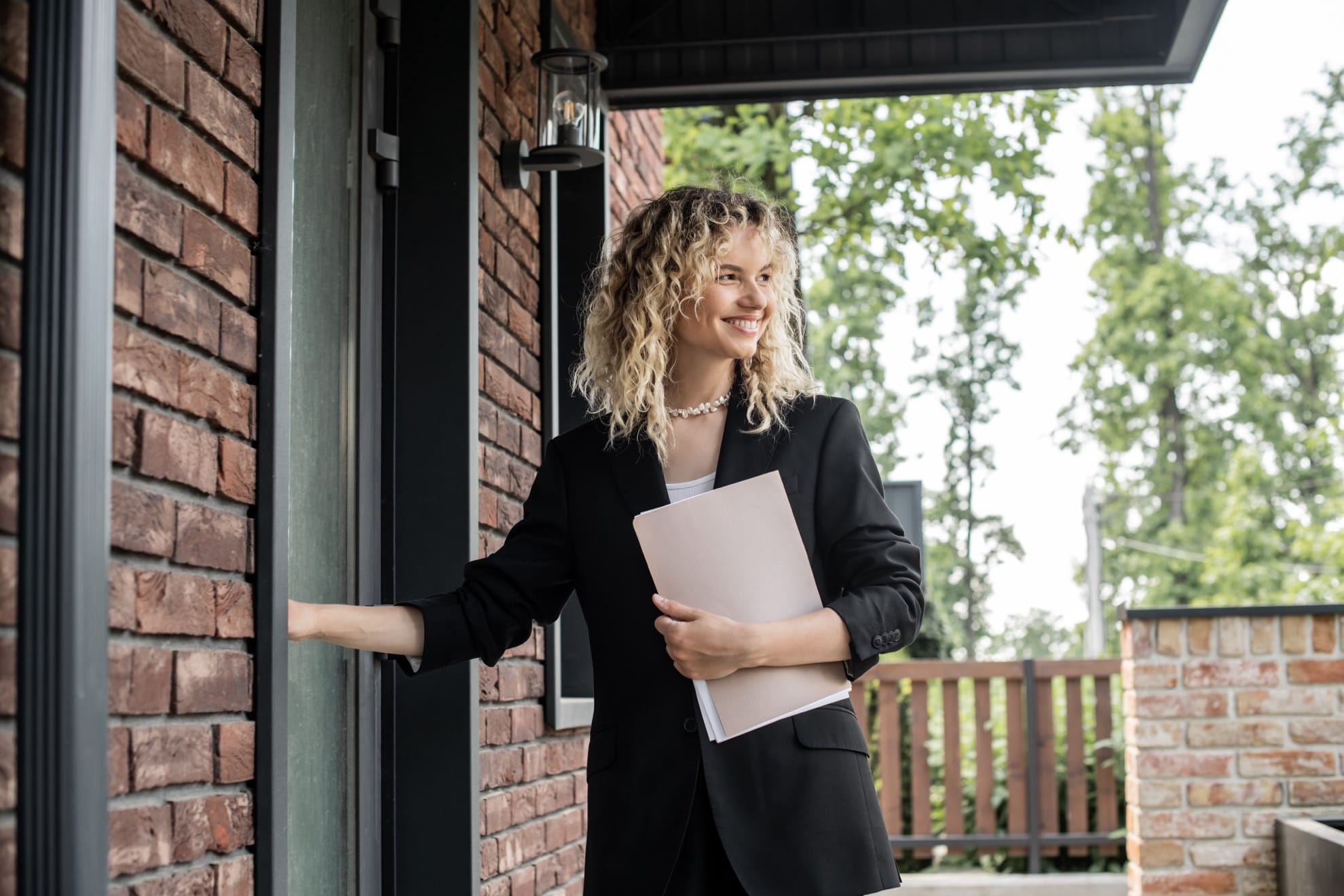 young housing lender waiting outside of house