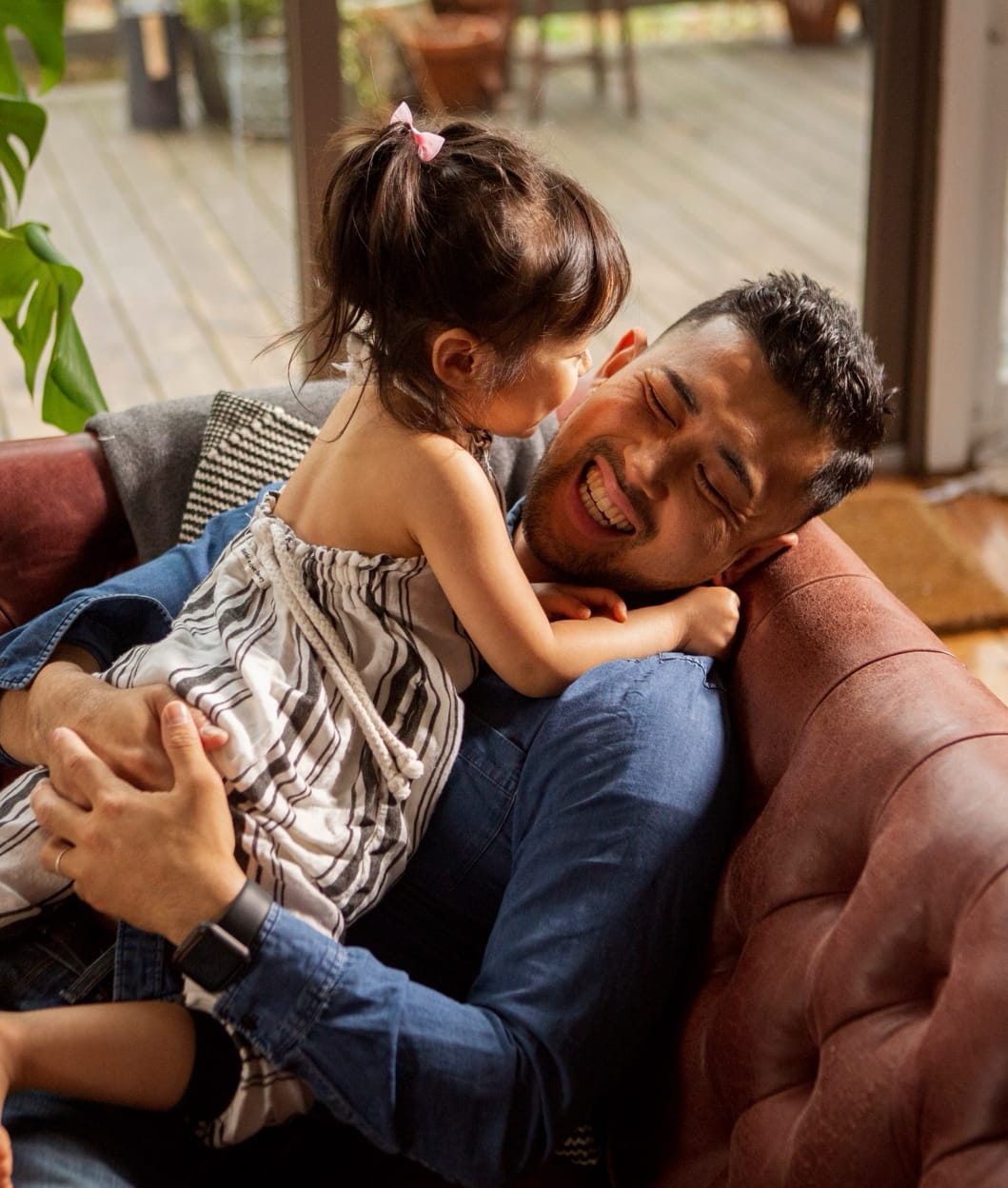 A man on the couch with his daughter