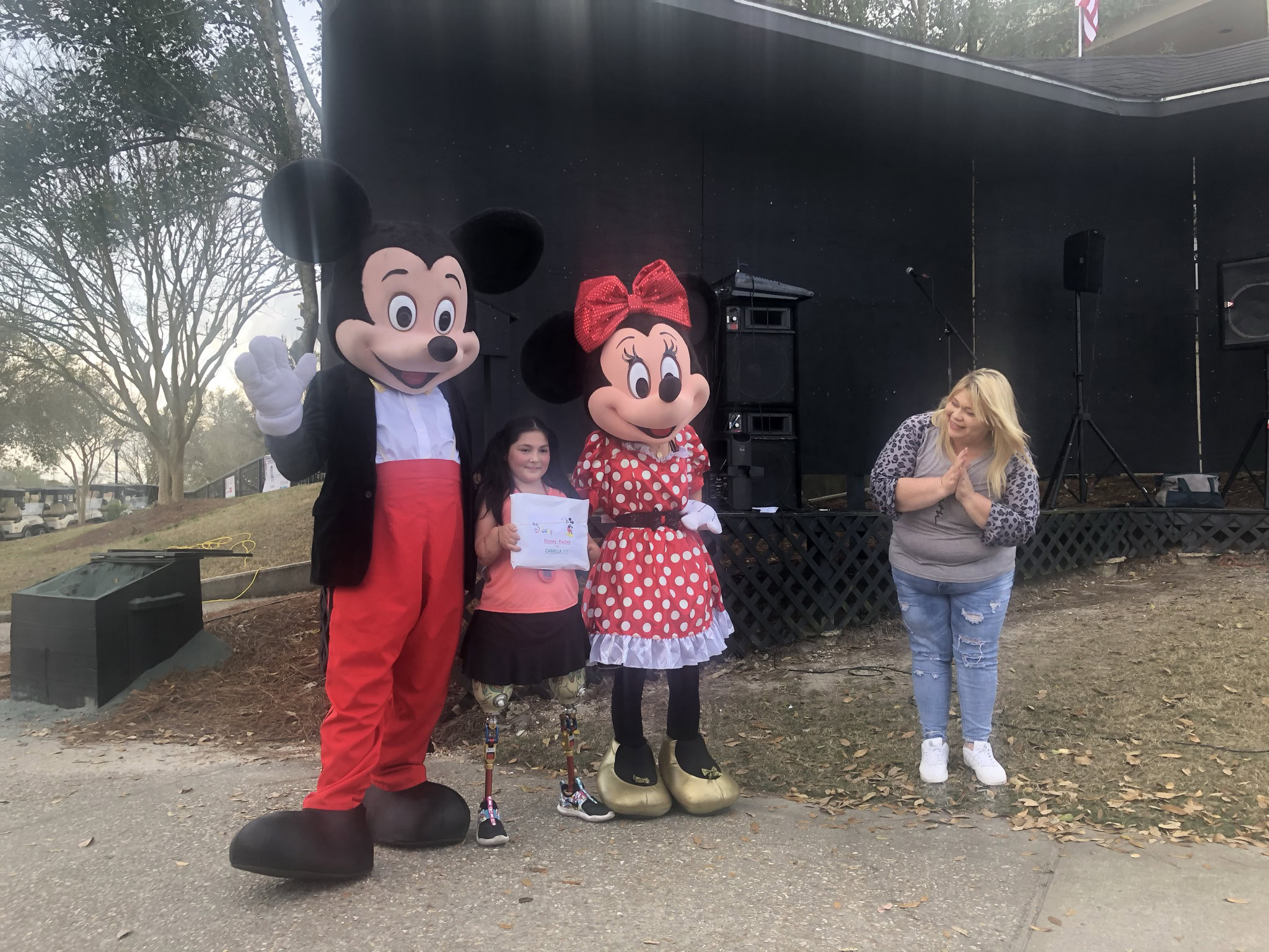 woman standing with Mickey Mouse and Minnie Mouse